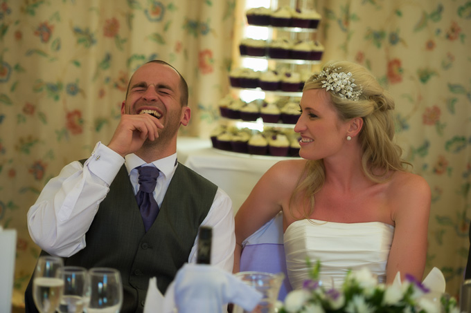 Wedding photograph of the groom laughing at the reception
