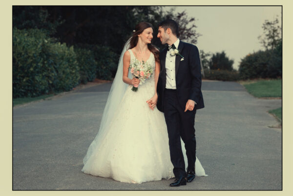 Wedding photography – the married couple holding hands walking down a lane