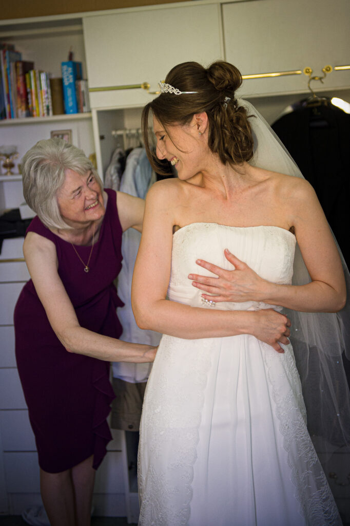 A bride laughing during wedding dress fitting in York captured by Howard Barnett.