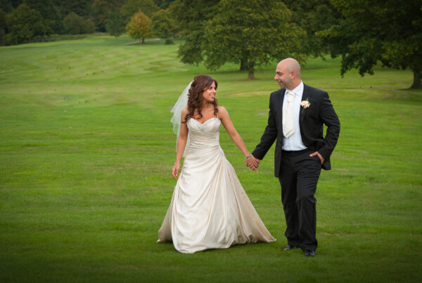 Newlyweds walking through the manicured gardens at Rudding Park, captured by Howard Barnett Photography.