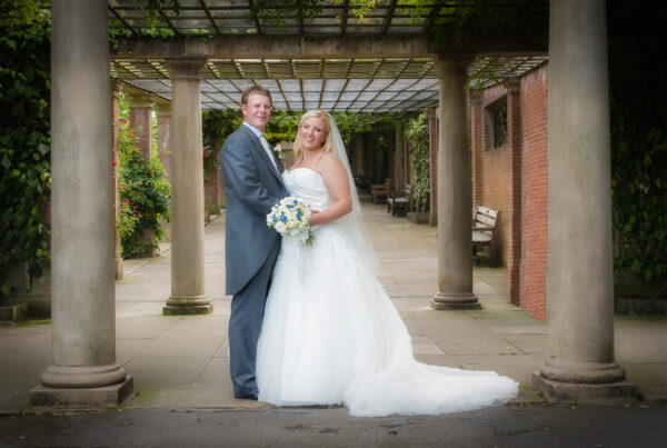 Professional wedding portrait of a couple under the historic stone pergola at Valley Gardens, Harrogate by Howard Barnett Photography.
