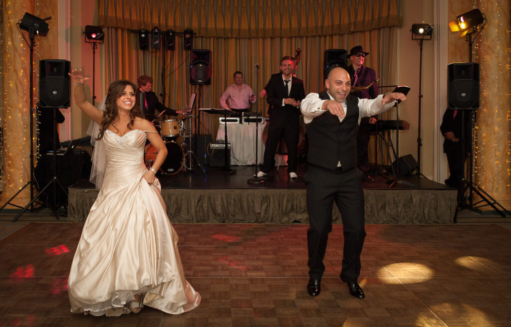 Bride and groom's first dance at their Rudding Park wedding reception with a live band in the background.