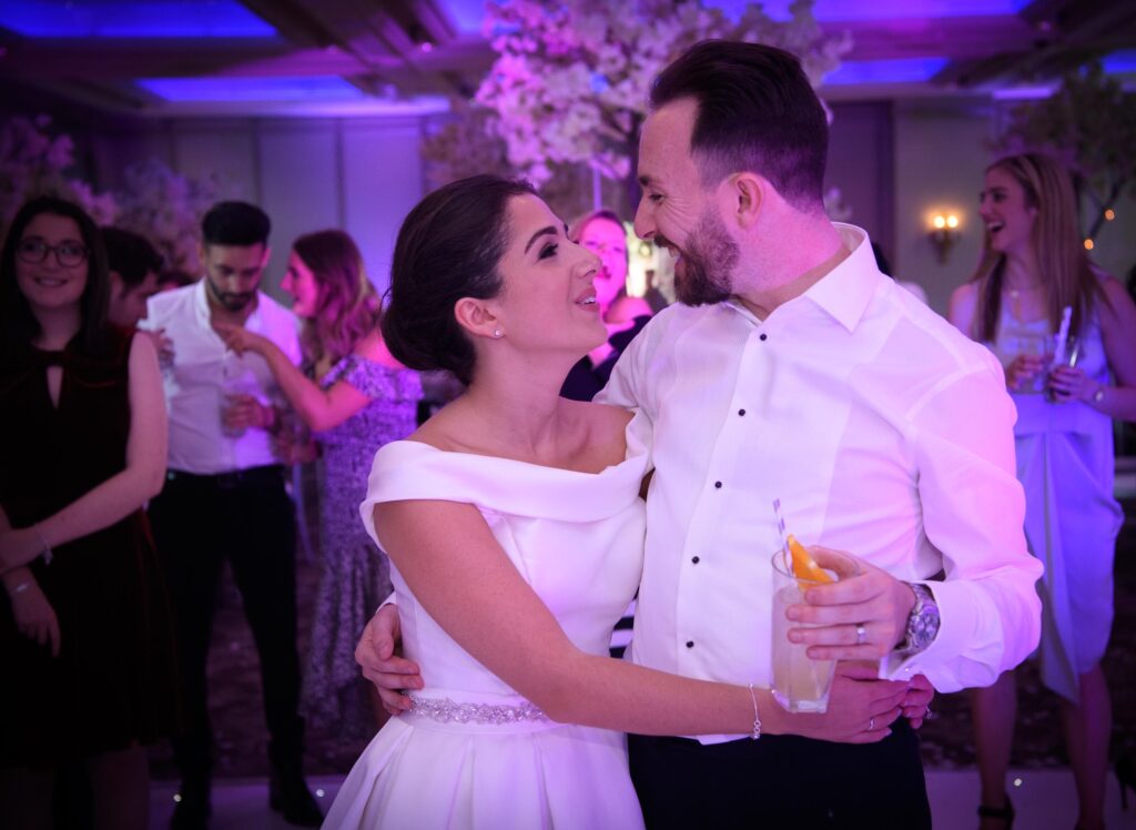 Natural wedding photography of a couple laughing together during their reception party in a Leeds ballroom.