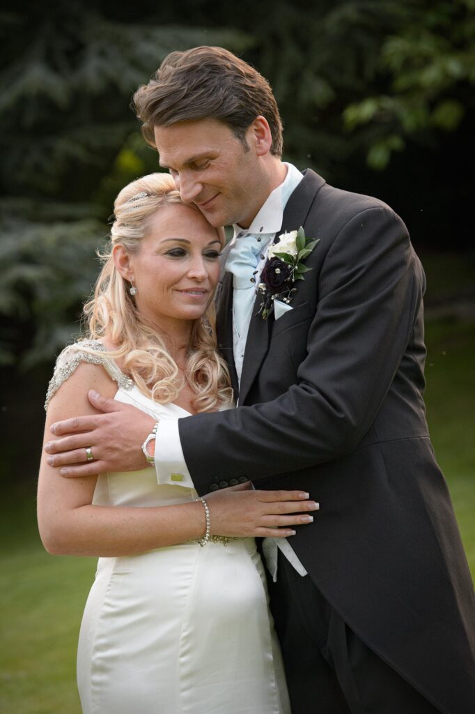 Close Embrace: "Emotional portrait of a newlywed couple embracing during a wedding photoshoot in Harrogate by Howard Barnett Photography."