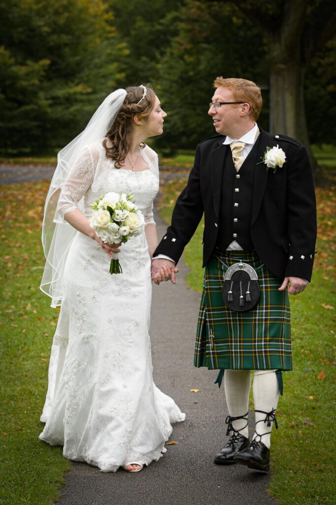 Bride and groom walking in a Harrogate park.