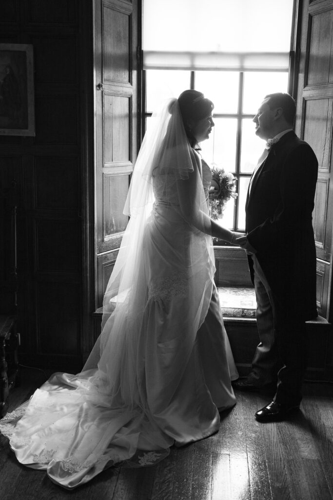 Professional wedding portrait of a bride and groom holding hands and looking at each other by Howard Barnett.